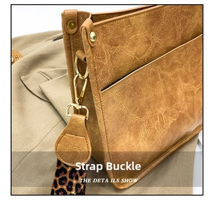 Macro detail of golden metal buckle on vintage brown leather bag with leopard strap