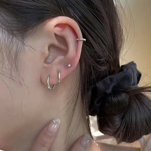 Titanium steel silver hoop earrings set shown on model ear for minimalist style