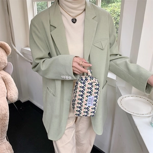 Détail d'une trousse à maquillage en velours côtelé fleuri avec dragonne et étiquette