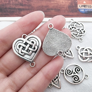 Macro view of antique silver Celtic knot heart and triangle charms for DIY jewelry making