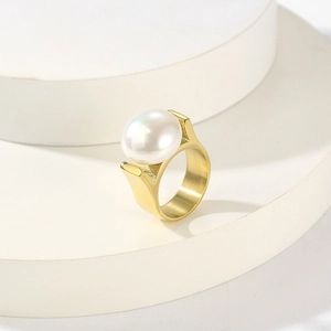 Detail eines luxuriösen Perlenrings mit poliertem goldenem Edelstahlfinish auf weißem Sockel