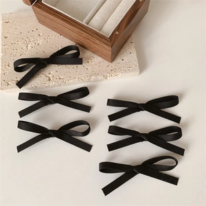 Set van 6 zwarte kantachtige strik-haarklemmen op een elegante, minimalistische basis