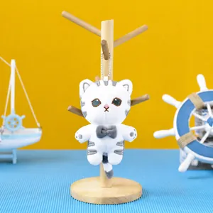 Detail view of a cute plush tiger cat keychain pendant with a bead chain on a display stand.