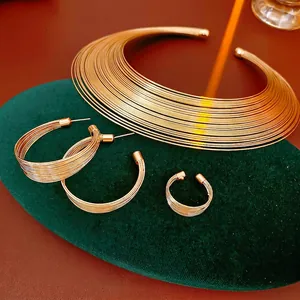 Gold multi-layer coil jewelry set featuring a choker necklace, hoop earrings and open ring