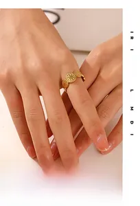 Close-up of gold geometric sunburst ring on finger with polished circular patterns