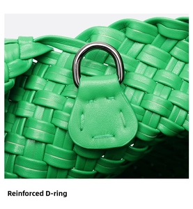 Detail of green woven leather bag featuring a reinforced silver metal D-ring buckle