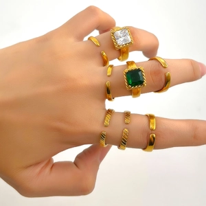 Détail de bagues dorées vintage avec pierres précieuses émeraude et zircon blanc