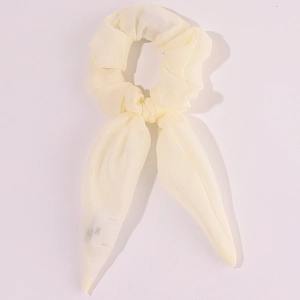 Detail of white chiffon scrunchie with bow showing soft fabric texture and ribbon