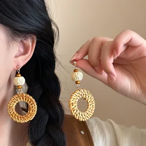 Bohemian rattan hoop earrings with wood beads and woven shell pendant on model