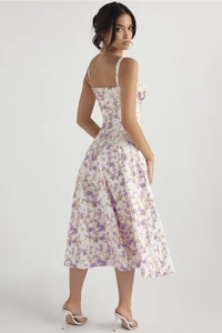 Detail of a white summer dress with purple floral print and thin spaghetti straps
