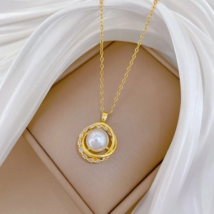 Close-up of golden spinning nest pendant with pearl and crystals in a jewelry box