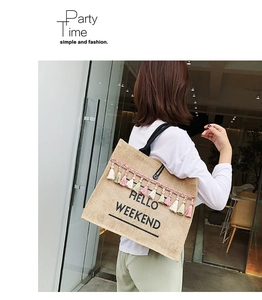 Detail of jute tote bag featuring colorful tassels and Hello Weekend print