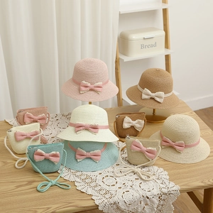 Detail of kids straw hats and matching bags with sweet polka dot bows and lace