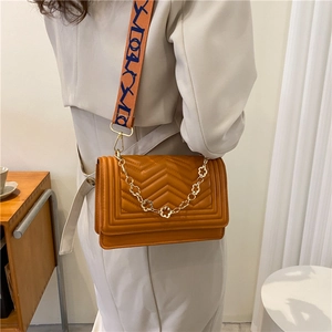 Caramel quilted crossbody bag with golden floral chain and artistic patterned strap
