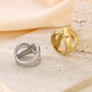 Macro detail of gold and silver cross rings on stone texture with mirror finish
