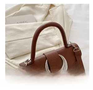 Détail du sac à main en cuir grainé avec une grande boucle en métal argenté en forme de lune
