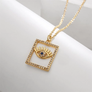 Detail of gold evil eye pendant necklace with blue zircon and sparkling crystals