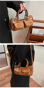 Detail of brown saddle bag showing dual front pockets and versatile shoulder strap