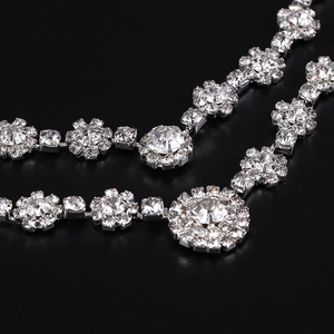 Sparkling silver flower necklace set with crystal rhinestones on a black background