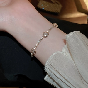 Detail of elegant camellia flower bracelet with white zircon inlay on model wrist