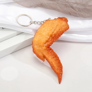 Realistic fried chicken wing keychain with golden finish on white silk background
