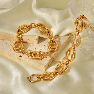 Détail de bracelets gourmettes dorés en acier inoxydable avec oxydes de zirconium