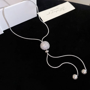 Detail of adjustable silver Y-necklace with zircon orb pendant and hanging tassels