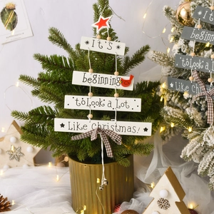 Close-up of wooden Christmas sign with holiday text, red birds and a checkered bow