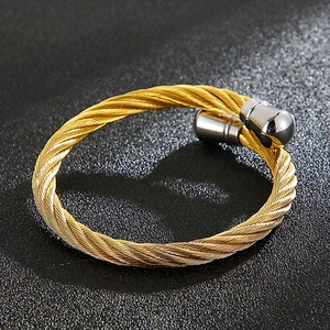 Detailed view of golden twisted cable wire bracelet with silver metal end caps