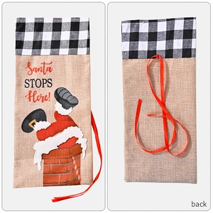 Detail showing burlap Christmas wine bottle bags with Santa design and plaid trim