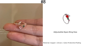 Detail of adjustable copper rings featuring vibrant heart zircons and gold plating