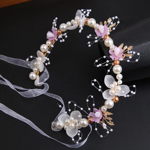Close-up of handmade floral headband with pearls, mesh flowers and pink petals
