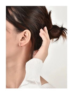 Close-up of minimalist gold hoop earrings with single row pavé cubic zirconia on model