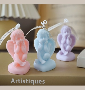 Detailed close-up of three angel-shaped scented candles in pink, blue, and purple hues