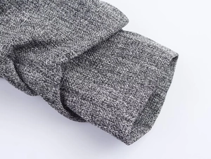 Detailed macro view of the folded cuffs and textured grey woven fabric on the blazer