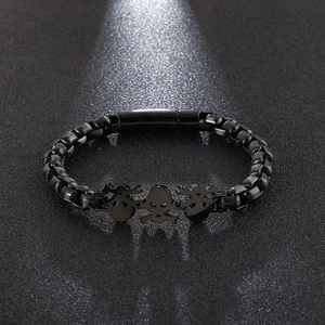 Detailed close-up of matte black punk skull bracelet with interlocking square chains
