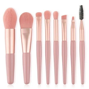 Flat lay of 8-piece mini makeup brush set with pink bristles and matte wood handles