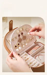 Macro shot of a brown leather jewelry box showing earring slots and velvet interior