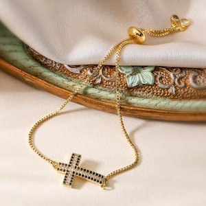 Bracelet croix plaqué or 18 carats avec zircons noirs et blancs et fermoir coulissant