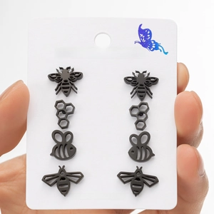 Set of 4 pairs of black stainless steel bee and honeycomb stud earrings on display card