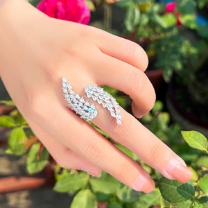 Détail de la bague ailes d'ange sertie de cristaux portée par un mannequin en extérieur