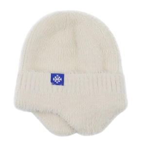 Detail of white plush knitted earflap hat with soft texture and blue snowflake label