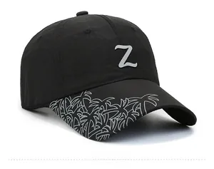 Detail view of black sun hat with Z logo and white tropical palm tree patterns on the brim