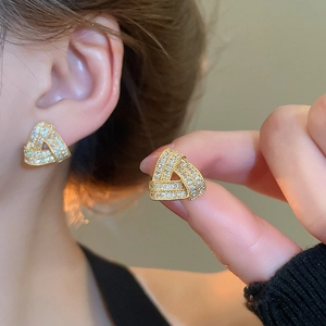 Detail of geometric triangle stud earrings with white cubic zirconia and gold finish