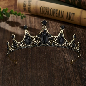 Macro detail of vintage bronze crown with black crystals on dark wooden background
