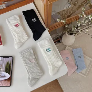 Detailed view of ribbed cotton crew socks with embroidery in five soft pastel colors
