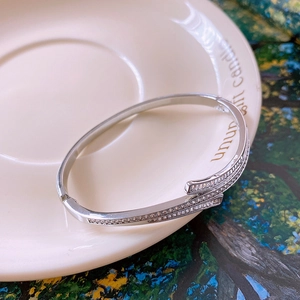 Detail shot of silver bypass bracelet with double-layered sparkling zircon settings