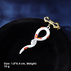 Detail view of a vintage snake brooch with enamel finish and gold bow knot, 1.8x6.4cm