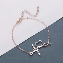 Detail of rose gold stethoscope bracelet with heart and heartbeat pulse design