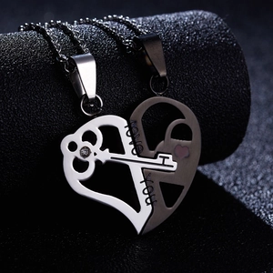 Detail shot of black and silver heart puzzle necklaces with key and lock symbols